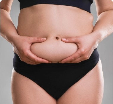 Mulher de bikini preto segurando a barriga